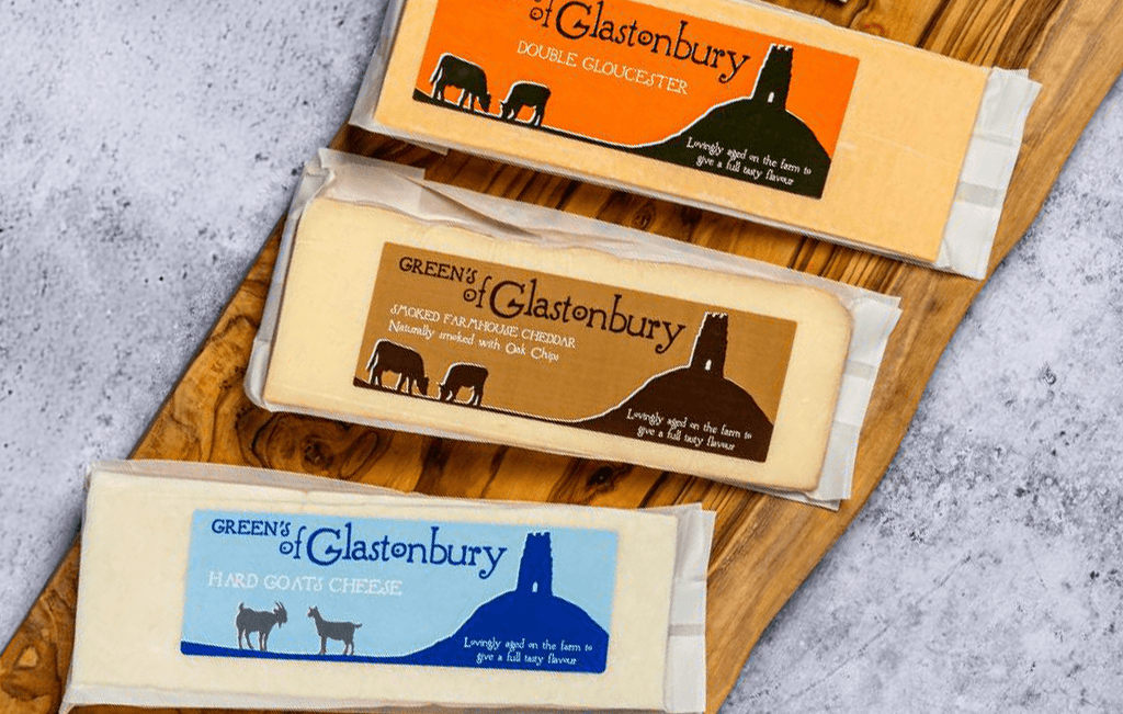Greens of Glastonbury range on a rustic wooden board.